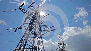 High-voltage transmission line. High voltage power pylons against blue sky. High voltage power line.