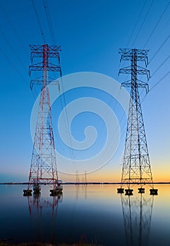 High voltage transmission lines crossing Wheeler Lake at dusk near Athens AL. Electricity pylons at sunset. Power and energy