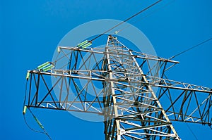 High-voltage transmission pylon against a blue sky. Close up