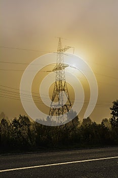 High voltage transmission tower near rural road