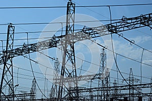 High voltage transmission towers, where many wires, have a clear sky background