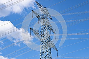 High voltages lines with a big power pylon against the blue  sky