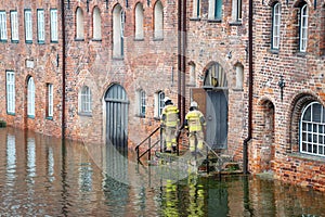 High water flooding the old town of Lubeck when the river Trave overflows its banks, specialists control water level and danger at photo