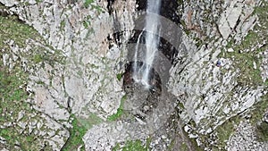 High waterfall among the rocks. View from a drone.