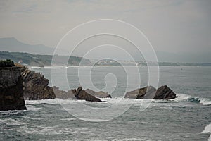 High waves hitting the sea coast near the cliff and rocks