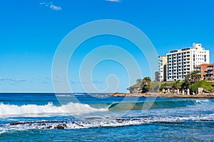 High waves and waterfront buildings on sunny day