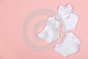 High white children`s socks for girls with big bows for party wear on a pink background