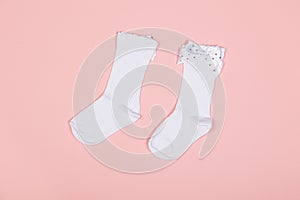 High white children`s socks for girls with big bows for party wear on a pink background