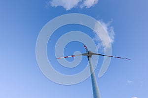 high windmill and soft clouds on blue sky for clean energy