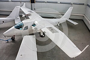 High-winged twin-engined light aircraft in hangar