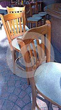 High wooden bar stools and a bar counter in the street