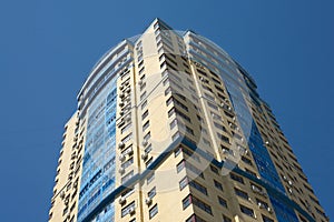 High yellow modern building on blue cloudless sky vertical view