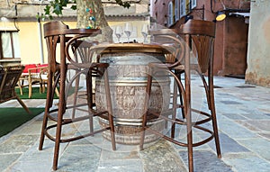 Highchairs with barrel table in traditional street cafe on coast of Corsica island , France.