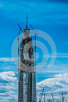 The highest building in Europe erection, skyscraper under construction with huge cranes on the construction site.