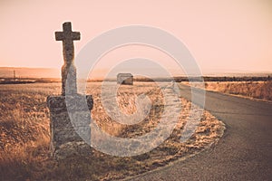 Highlighted cross memorial monument along the side of the road