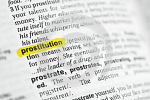 Highlighted English word prostitution and its definition at the dictionary. photo