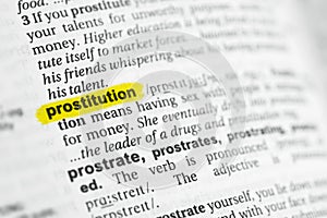 Highlighted English word & x22;prostitution& x22; and its definition at the dictionary photo