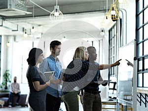 Highlighting the most important parts. Shot of a young businesswoman giving a presentation to her colleagues using a