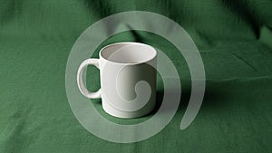 Highlighting the mug s smooth surface against the contrasting green