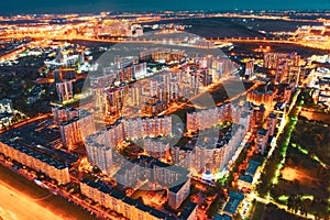Highly populated residential area of high-rise buildings and street lighting, aerial view at night photo