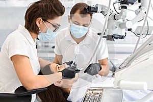 Highly qualified dentists making treatment in modern dental clinic