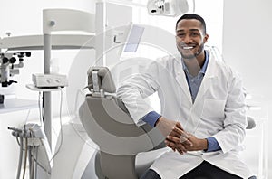 Highly qualified young dentist posing at modern clinic photo