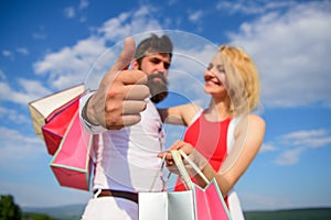 Highly recommend sale tips. Advice shop now. Couple with shopping bags cuddle blue sky background. Man with beard shows