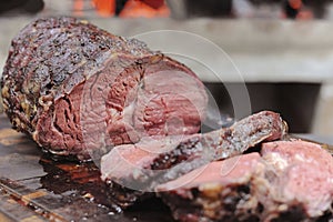 Highly seasoned slow-roasted beef sliced on a chopping board. Isolated on a brown background.