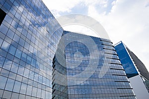 Highrise glass building with sky and clouds reflection. geometric