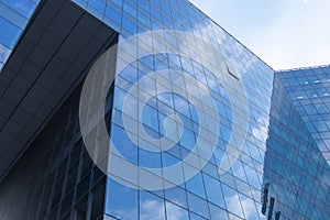 Highrise glass building with sky and clouds reflection. geometric shapes