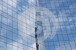 Highrise glass building with sky and clouds reflection. geometric shapes