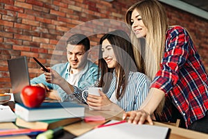 Highschool students looking on laptop together