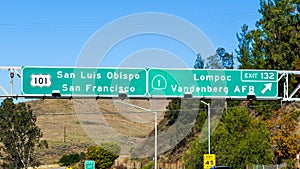 Highway 101 navigational road signage providing guidance towards San Luis Obispo / San Francisco and Lompoc / Vandenberg AFB exit