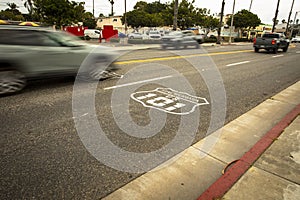 Highway 101 sign painted on the black asphalt road with blurred cars passing by