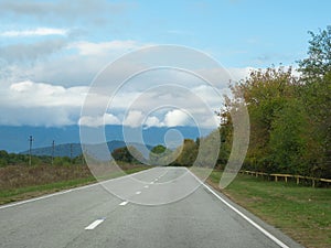 Highway through the autumn forest natural way concept, road to the caucasian forest nature field, relaxing with ecological