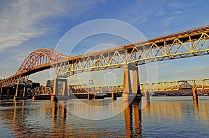 Highway bridge and railroad bridge are bathed in the golden rays of the sunset