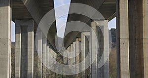 Highway bridge underpass structure with concrete columns on a blue sky background