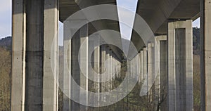 Highway bridge underpass structure with concrete columns on a blue sky background