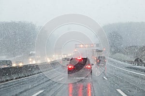 Highway with cars in winter with snow fall