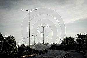 Highway curve road overpass nature landscape background dark tone mist day time street tall lanterns trees bushes