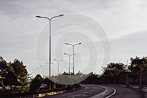 Highway curve road overpass nature landscape background dark tone mist day time street tall lanterns trees bushes