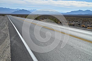 Highway in Death Valley desert blue mountain range