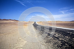 Highway through the desert next to the ocean in National Park Paracas in Ica, Peru