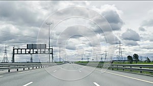 Highway driving in the fast lane with speed signs of 130 km per hour on a cloudy day