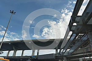 Highway express way overpass underconstruction across the cross road in thai city on blue sky back ground