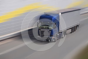 Highway. A fast moving truck on a motorway surrounded by sound b