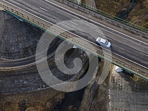 Highway intersection junction summer morning with white car. Aerial Top View