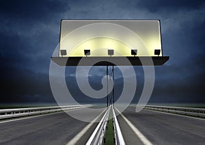 Highway with lighted blank billboard and evening sky