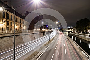 Highway with lights and cars leading through night city