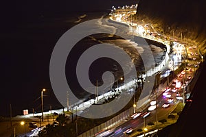 highway with a lot of traffic in the green crust very close to the beaches of miraflores at night aerial view peru